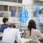 Teacher with futuristic interface with body on it pointing student