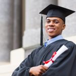 african american male graduate standing outside college